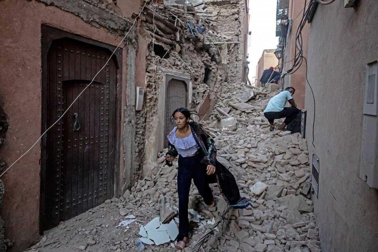 Moradora corre para fugir de área completamente destruída por um terremoto que atingiu o Marrocos