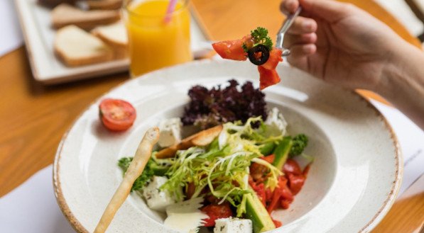 Pessoa comendo salada no jantar