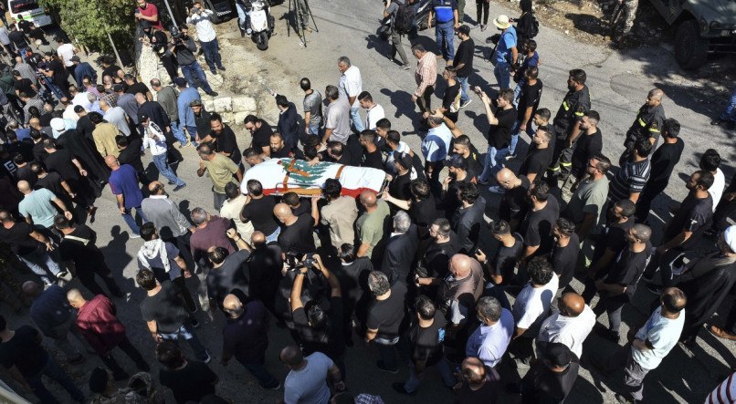 Caixão do jornalista morto em bombardeio é carregado, envolto à bandeira do Líbano