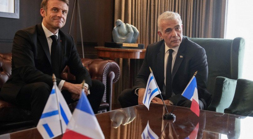 O presidente francês Emmanuel Macron posa com o líder da oposição israelense Yair Lapid antes de suas conversações em Jerusalém