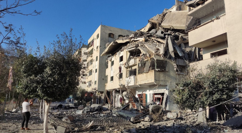 Um palestino tira fotos de um prédio destruído no distrito de Tal al-Hawa, no oeste da cidade de Gaza, em 30 de outubro de 2023