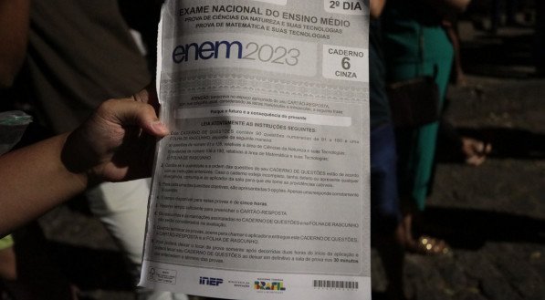 Imagem: estudante segurando prova do ENEM 2023.