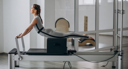 Woman practising pilates in a pilates reformer