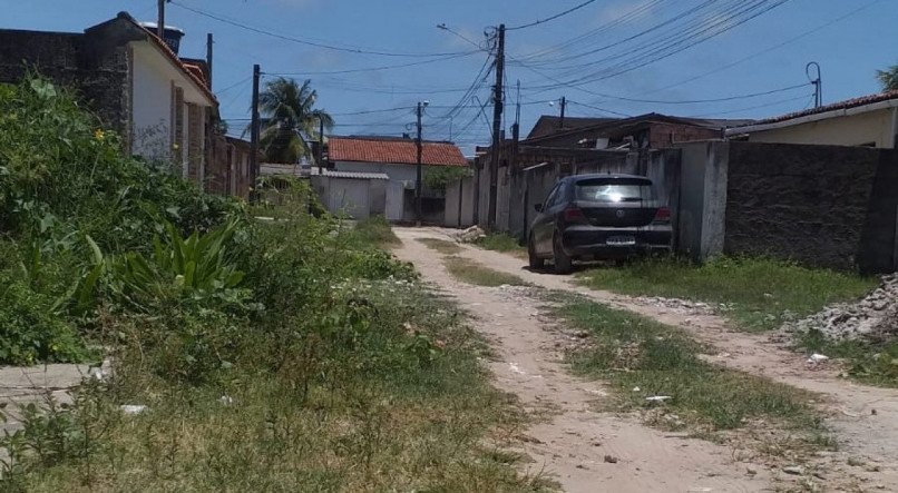 Mato cresce por falta de limpeza em rua sem asfalto em Jaboatão dos Guararapes