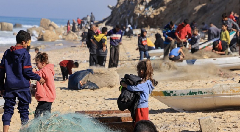 Em uma das praias do estreito território palestino, na Faixa de Gaza, localizado entre Israel, Egito e o Mediterrâneo, famílias e crianças palestinas se divertem na areia