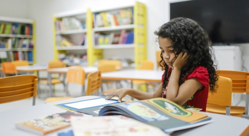 Todo leitor precisa de livros: criança na biblioteca do Compaz, no Recife