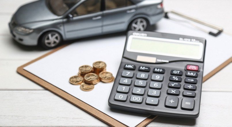 car model,calculator and coins on white table
