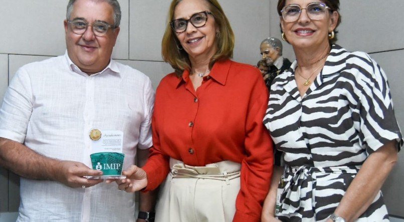 O deputado Augusto Coutinho recebe das superintendentes Tereza Campos e Sílvia Vidon homenagem do Imip