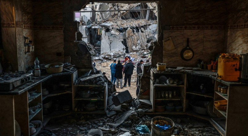 Pessoas verificam os danos após o bombardeio israelense em Rafah, no sul da Faixa de Gaza, em 3 de fevereiro de 2024, enquanto os combates continuam entre Israel e o grupo palestino Hamas