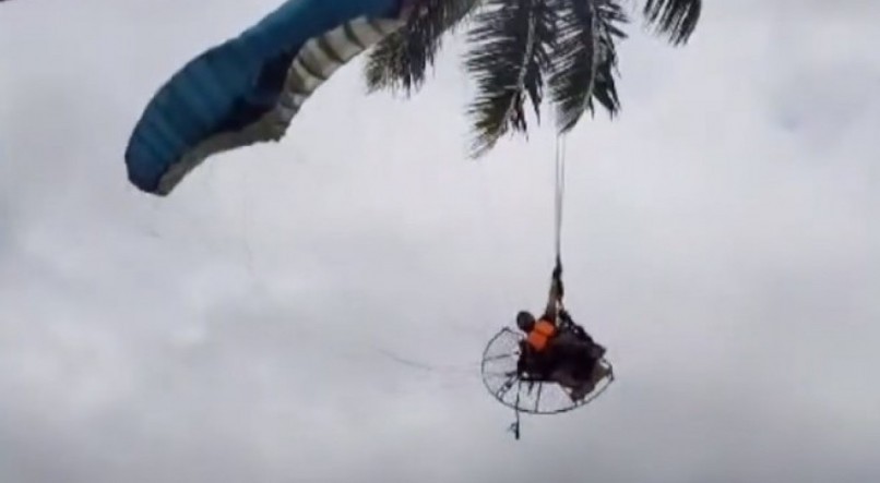 Paramotor colide em coqueiro e piloto fica pendurado na praia de Itapuama.