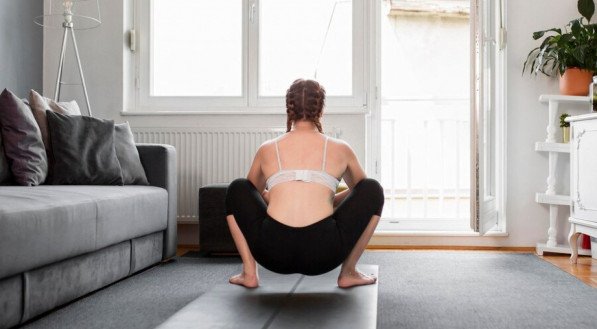 Mulher agachada em casa treino