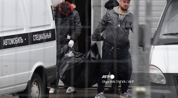 Agentes carregam corpo de vítima do ataque terrorista do Estado Islâmico à casa de concertos Crocus City Hall, em Moscou