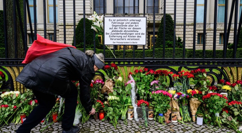 Uma mulher coloca flores em um memorial improvisado em frente à embaixada russa em Berlim, neste domingo (24), dois dias após um ataque armado em Krasnogorsk, nos arredores de Moscou