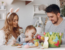 Família pintando ovos de Páscoa com criança