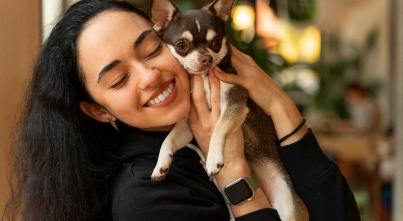 Mulher com cachorro pequeno nos braços fofo