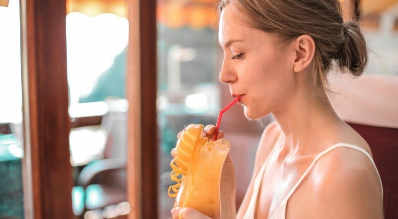 Mulher bebendo suco par aumentar a imunidade.