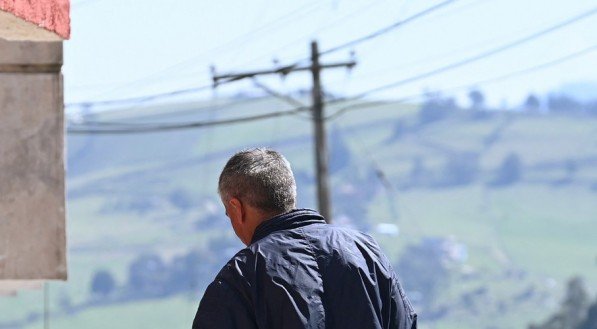 Homem carrega água potável em baldes em La Calera, perto de Bogotá