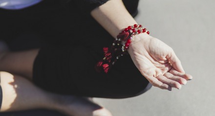 Imagem: mão com diversas pulseiras vermelhas