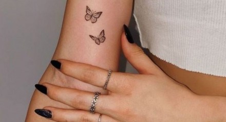 Tatuagem minimalista de duas borboletas