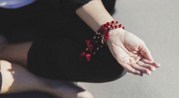 Imagem: mão com diversas pulseiras vermelhas