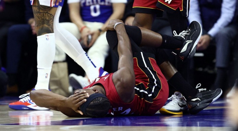 Jimmy Butler, do Miami Heat, caído no chão após lesão no joelho