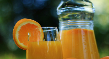 Imagem de jarra e copo de suco de laranja natural