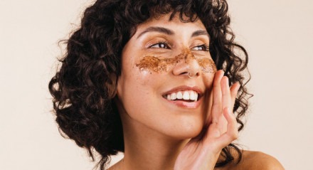 Imagem de mulher fazendo skin care com mÃ¡scara de cafÃ© no rosto