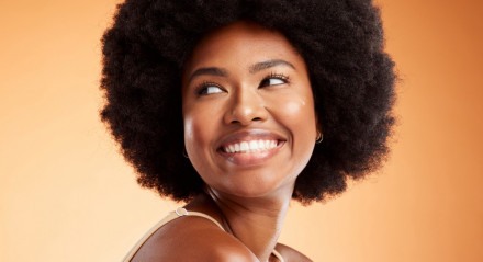 Imagem de mulher sorrindo; cabelos cacheados; cabelos crespos