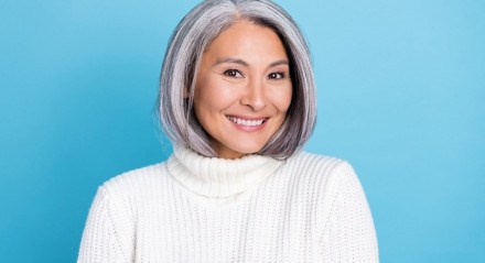 Imagem de uma mulher com cabelo curto grisalho sorrindo