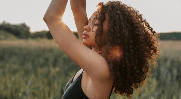 Mulher com o cabelo cacheado bem cuidado e hidratado.