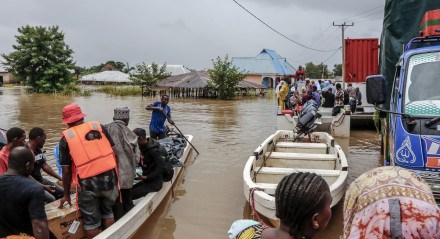 Moradores são resgatados em barcos numa área fortemente afetada por inundações após chuvas torrenciais no distrito de Rufiji