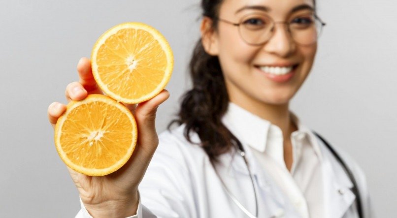 Mulher esgurando uma laranja na mão. 