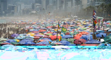Imagem ilustra lotação na praia do Rio de Janeiro com guarda-sóis; população deve ir à praia no feriado