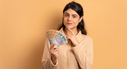 Imagem ilustrativa de uma mulher com dinheiro!