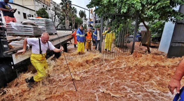 Imagem de pessoas em meio às fortes chuvas que atingem o estado do Rio Grande do Sul