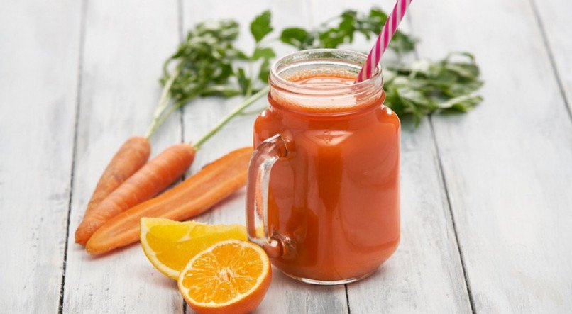 Imagem de um copo de suco de laranja com cenoura e gengibre