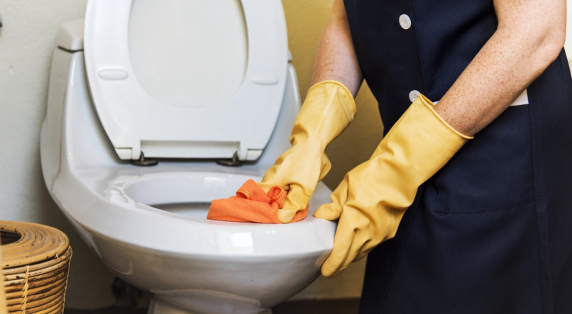 Imagem ilustrativa de pessoa limpando banheiro para tirar cheiro de urina