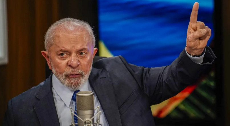 Lula fala em microfone de podcast enquanto aponta para lateral. Presidente aumentou o engajamento com publicações sobre o RS