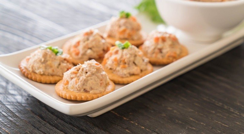 tuna spread with cracker on wood board