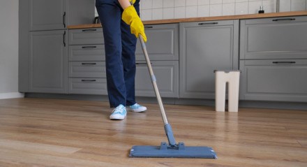 Imagem ilustrativa de pessoa usando mop para limpar piso encardido
