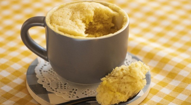 Bolo de caneca de banana dentro d euma caneca cinza com pires