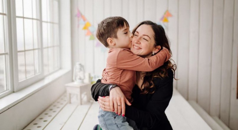 M&atilde;e segurando crian&ccedil;a no colo