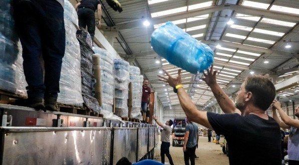 Contraponto: voluntários carregam caminhão em área de coleta para organizar doações destinadas às vítimas das enchentes no Rio Grande do Sul