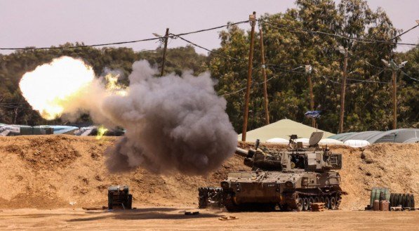 Uma unidade de artilharia móvel israelense dispara um projétil de uma posição fronteiriça no sul de Israel em direção à Faixa de Gaza