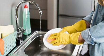 Imagem ilustrativa de pessoa limpando pia