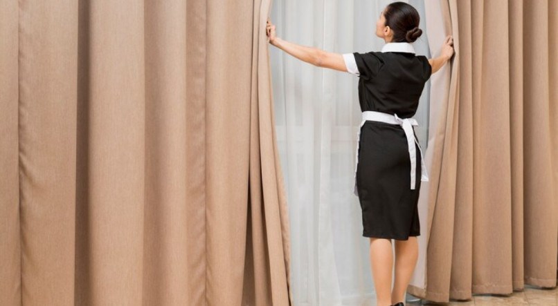 Imagem ilustrativa de pessoa limpando cortina sem tirar do suporte