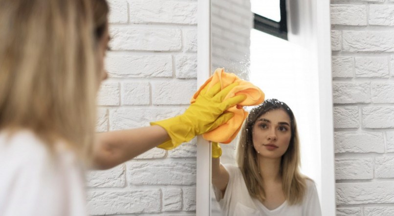 Imagem ilustrativa de mullher ensinando como limpar espelho manchado