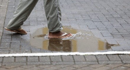 Imagem ilustrativa de pessoa andando sem proteção em poças de água 