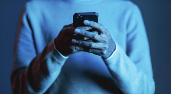 Na imagem, homem mexendo no celular
