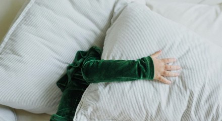 Imagem ilustrativa de uma pessoa deitada com uma camisa verde e um travesseiro no rosto